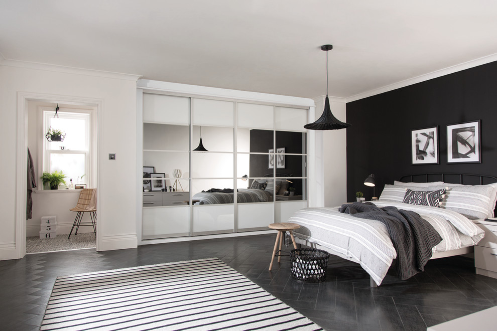 Aménagement d'une chambre d'amis contemporaine de taille moyenne avec un mur blanc, parquet foncé et un sol noir.