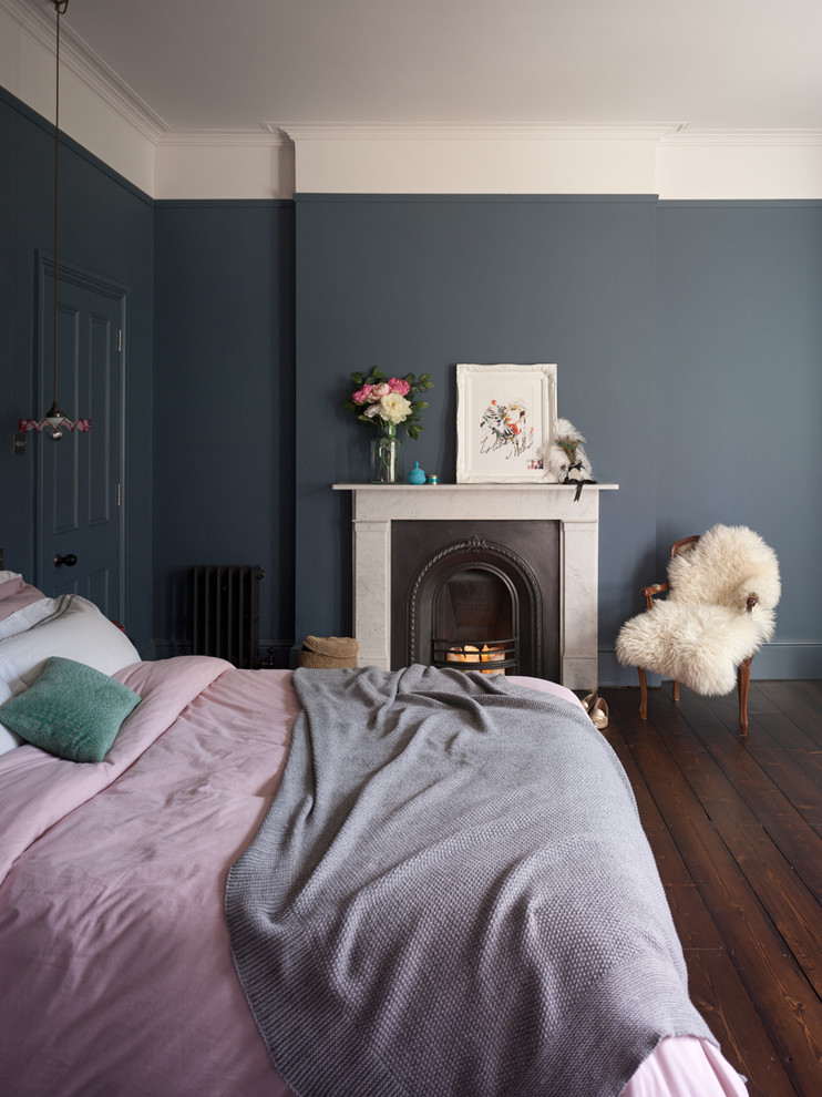 Stilmix Hauptschlafzimmer mit grauer Wandfarbe, dunklem Holzboden, Kamin und Kaminumrandung aus Stein in Kent