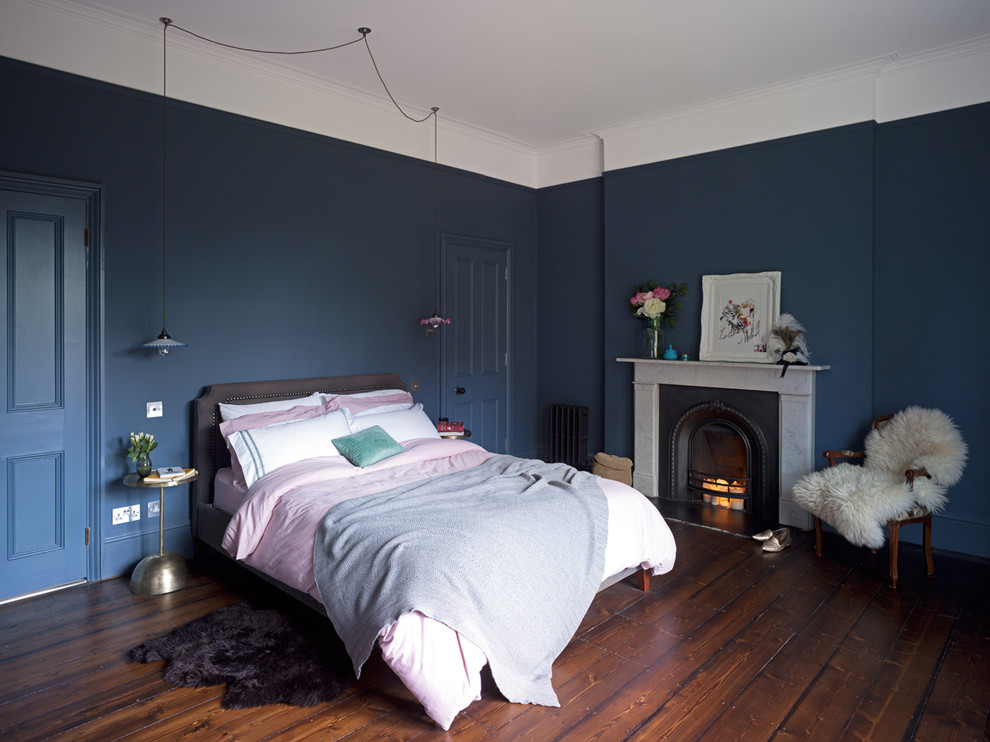 Aménagement d'une chambre parentale éclectique avec un mur gris, parquet foncé, une cheminée standard et un manteau de cheminée en pierre.