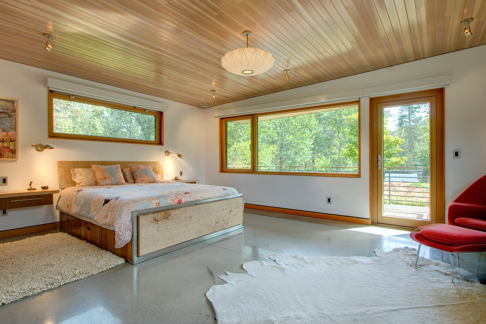 Cette image montre une chambre design avec un mur blanc et sol en béton ciré.