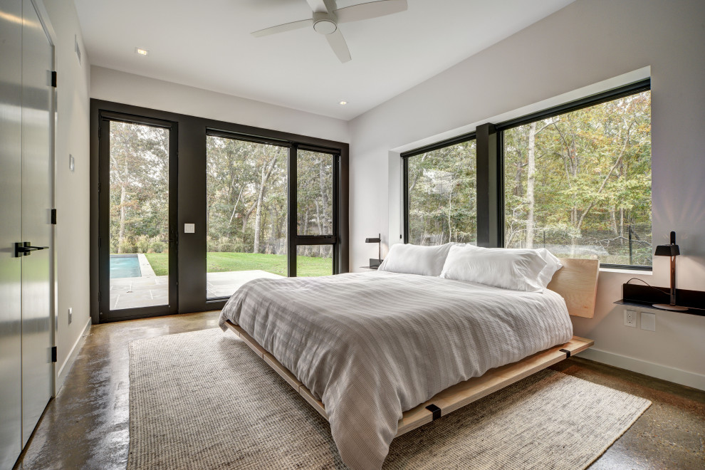 Ejemplo de dormitorio rústico con paredes blancas, suelo de cemento y suelo marrón