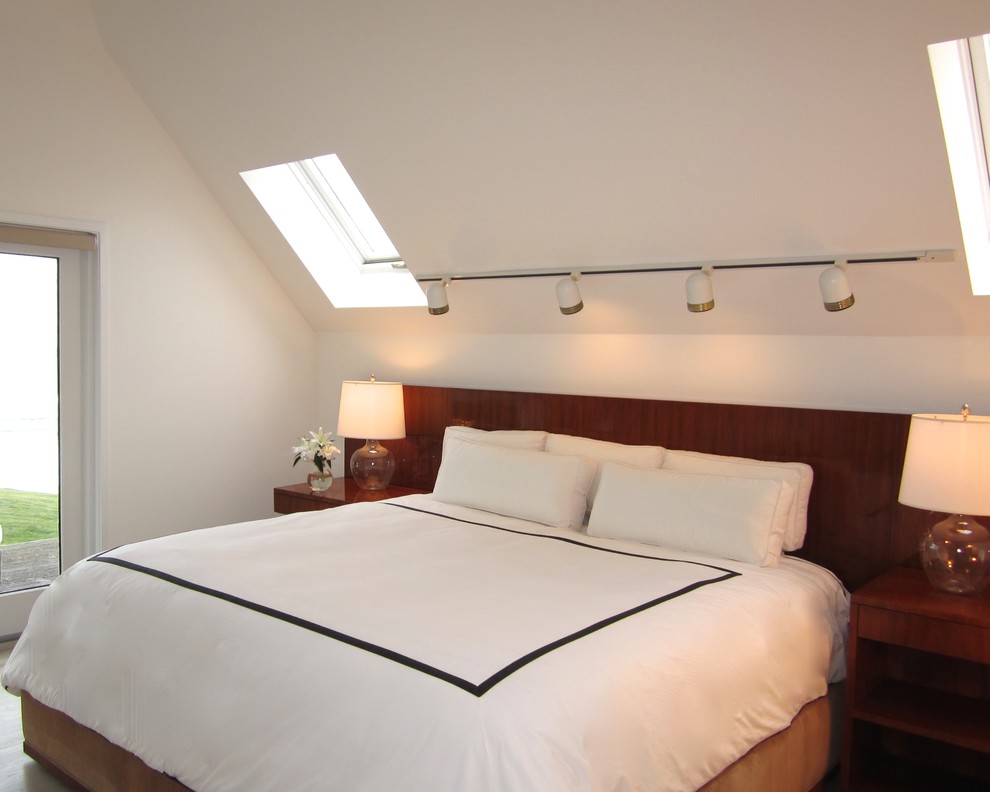 Foto de dormitorio principal costero de tamaño medio con paredes blancas y suelo de madera clara