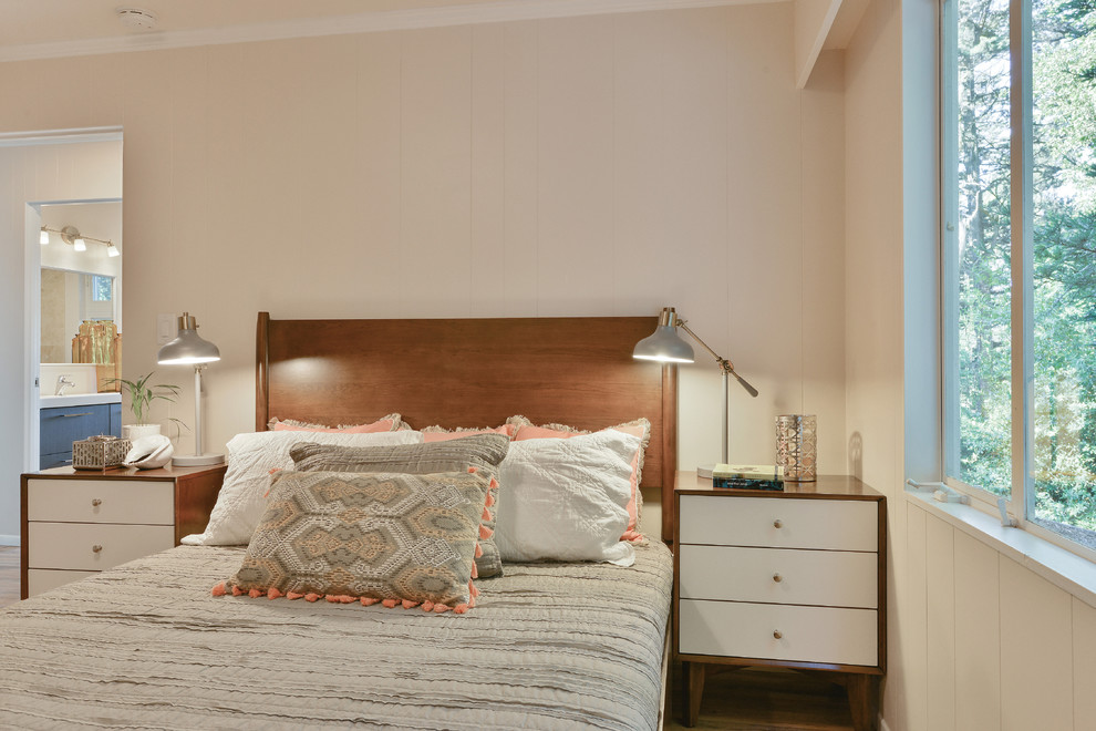 Idée de décoration pour une chambre d'amis design de taille moyenne avec un mur beige, un sol en bois brun et aucune cheminée.