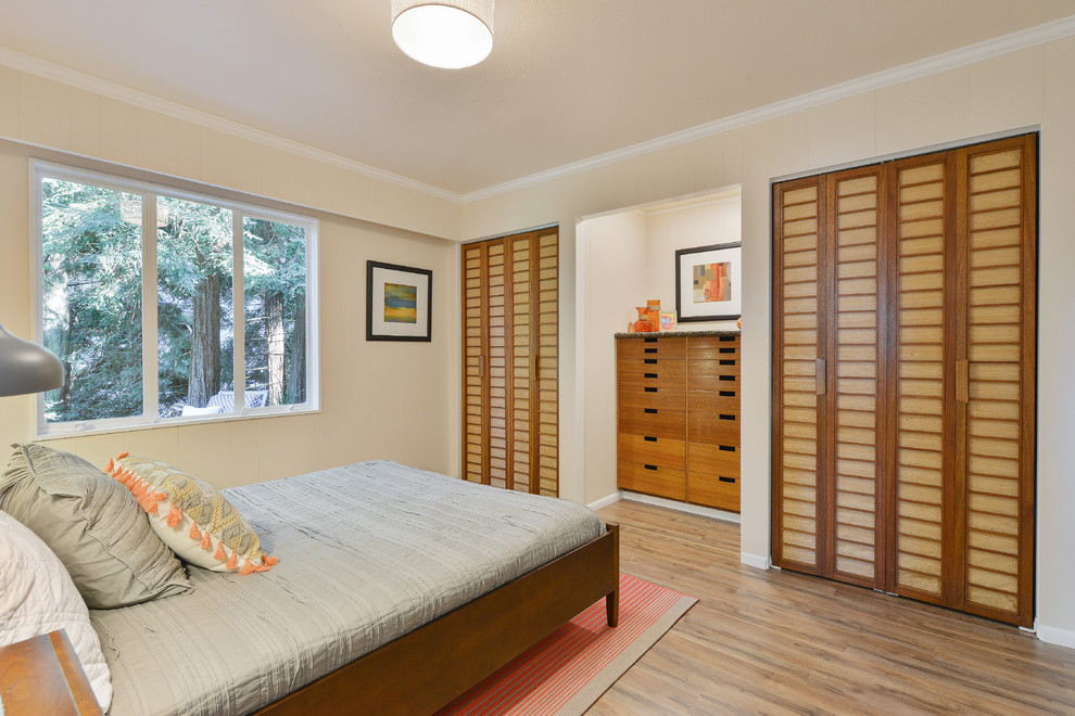 Réalisation d'une chambre d'amis design de taille moyenne avec un mur beige, un sol en bois brun et aucune cheminée.