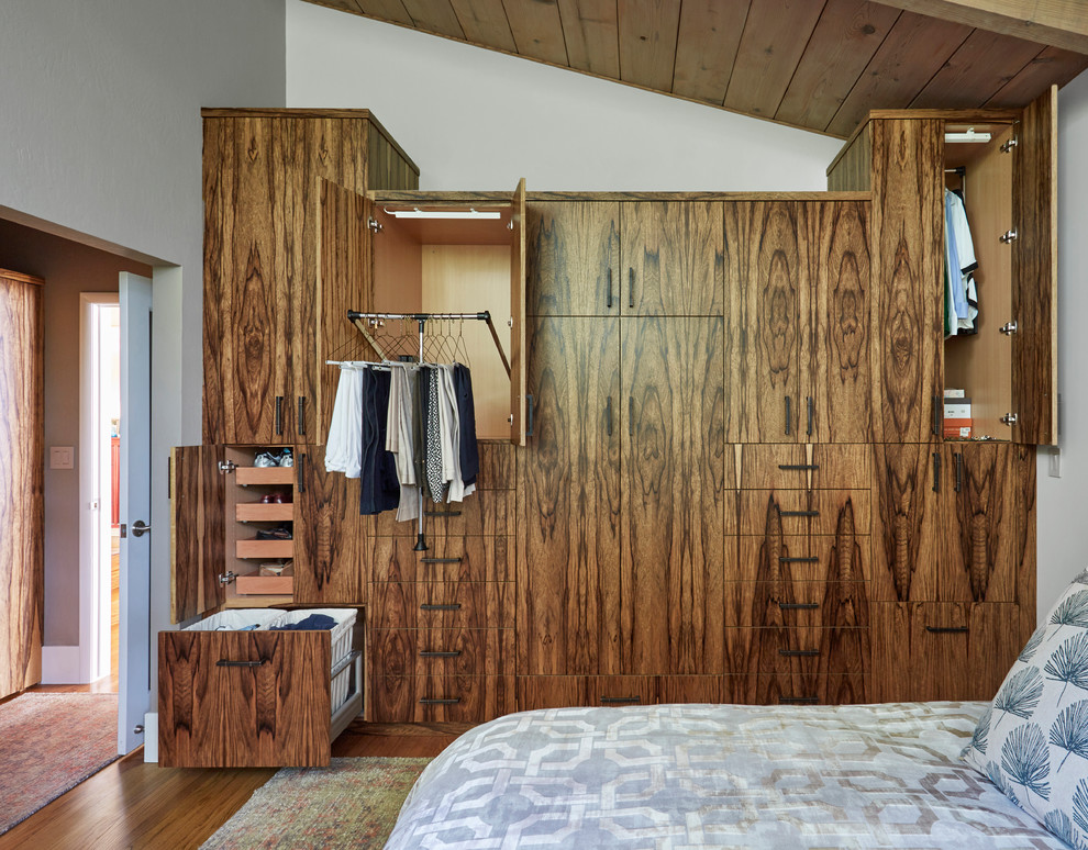 Ejemplo de dormitorio principal retro de tamaño medio sin chimenea con paredes beige, suelo de madera clara y suelo marrón