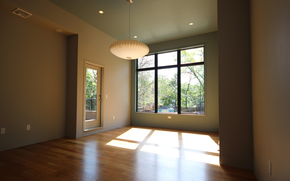 Foto de dormitorio minimalista sin chimenea con paredes verdes y suelo de madera clara