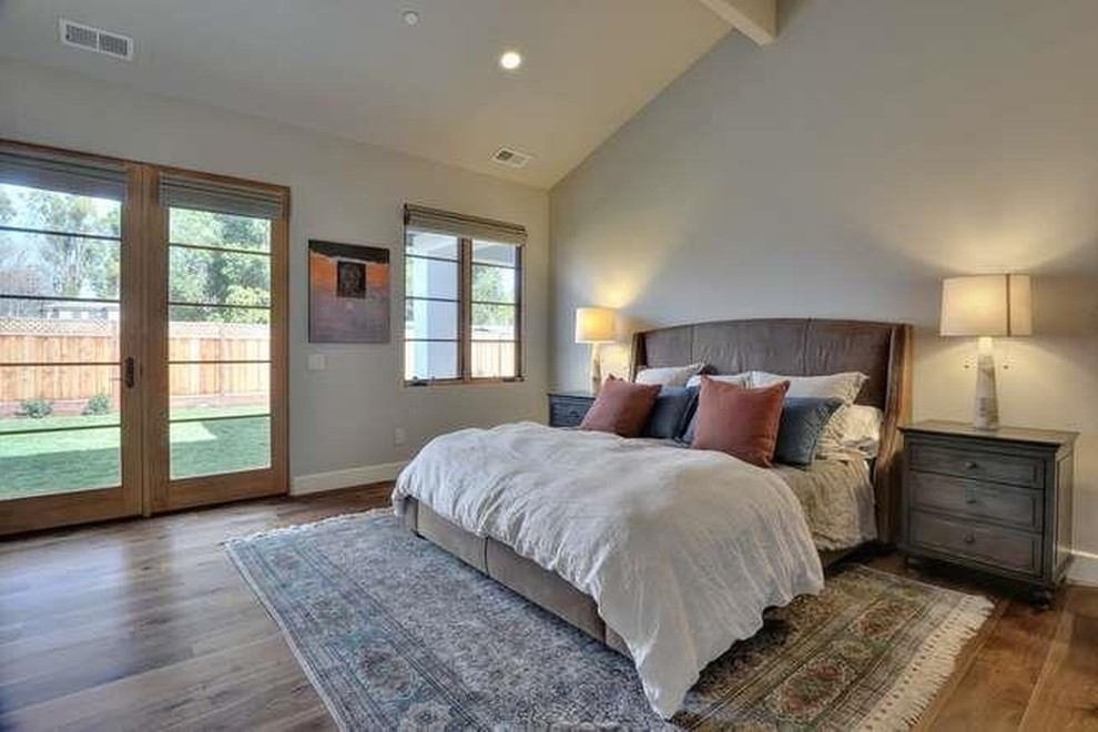 Foto de dormitorio principal rústico extra grande con paredes beige, suelo de madera en tonos medios, todas las chimeneas y marco de chimenea de yeso
