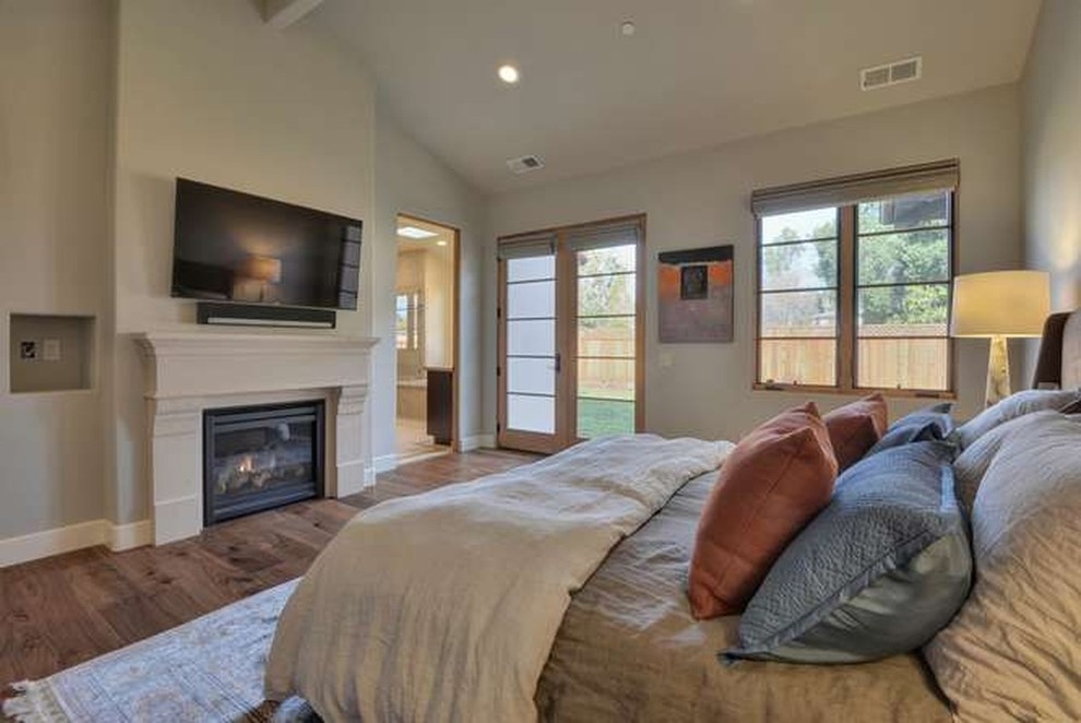 Geräumiges Uriges Hauptschlafzimmer mit beiger Wandfarbe, braunem Holzboden, Kamin und verputzter Kaminumrandung in San Francisco
