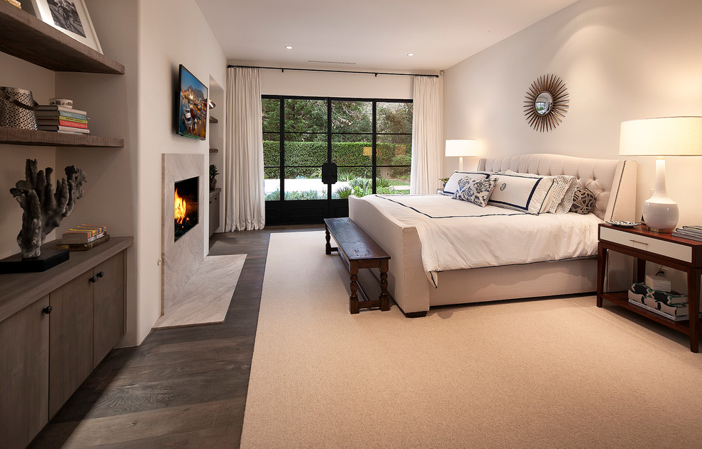 Design ideas for a large contemporary bedroom in Santa Barbara with white walls, carpet, a standard fireplace and a stone fireplace surround.