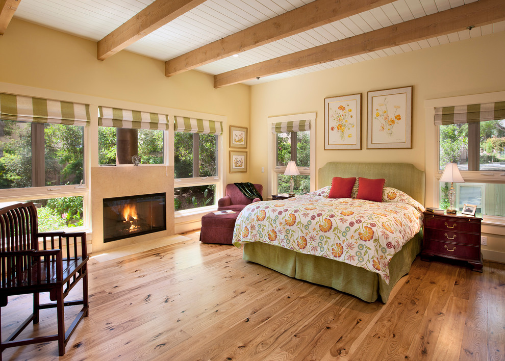 На фото: спальня в классическом стиле с бежевыми стенами, паркетным полом среднего тона и горизонтальным камином с