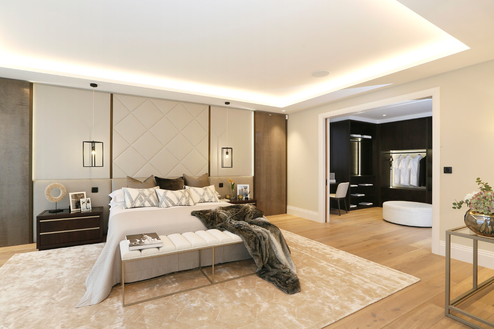 Immagine di una camera da letto design con pareti beige, pavimento in legno massello medio e pavimento marrone