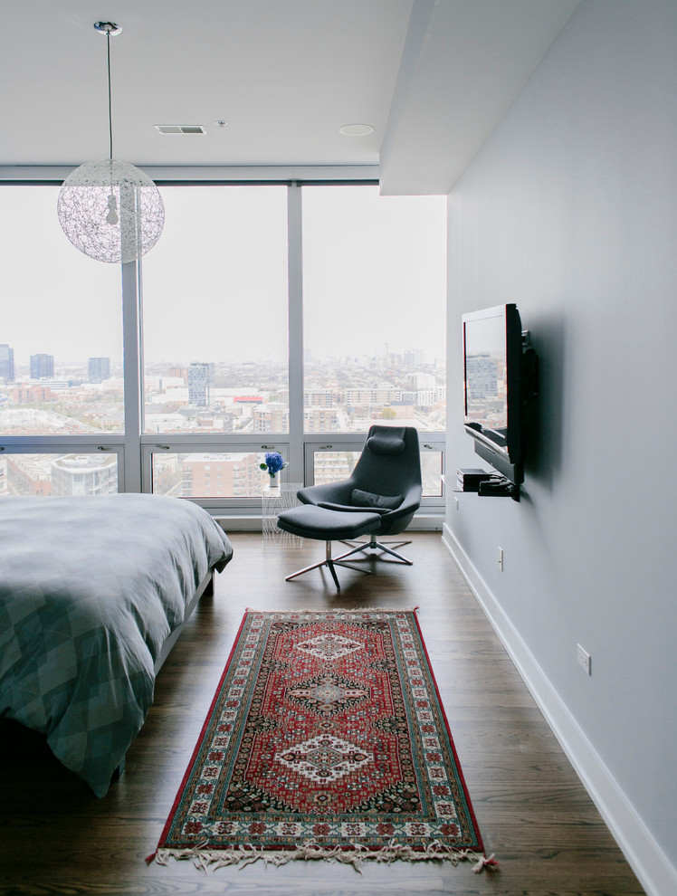 Diseño de dormitorio principal minimalista de tamaño medio con paredes azules, suelo de madera en tonos medios y suelo marrón