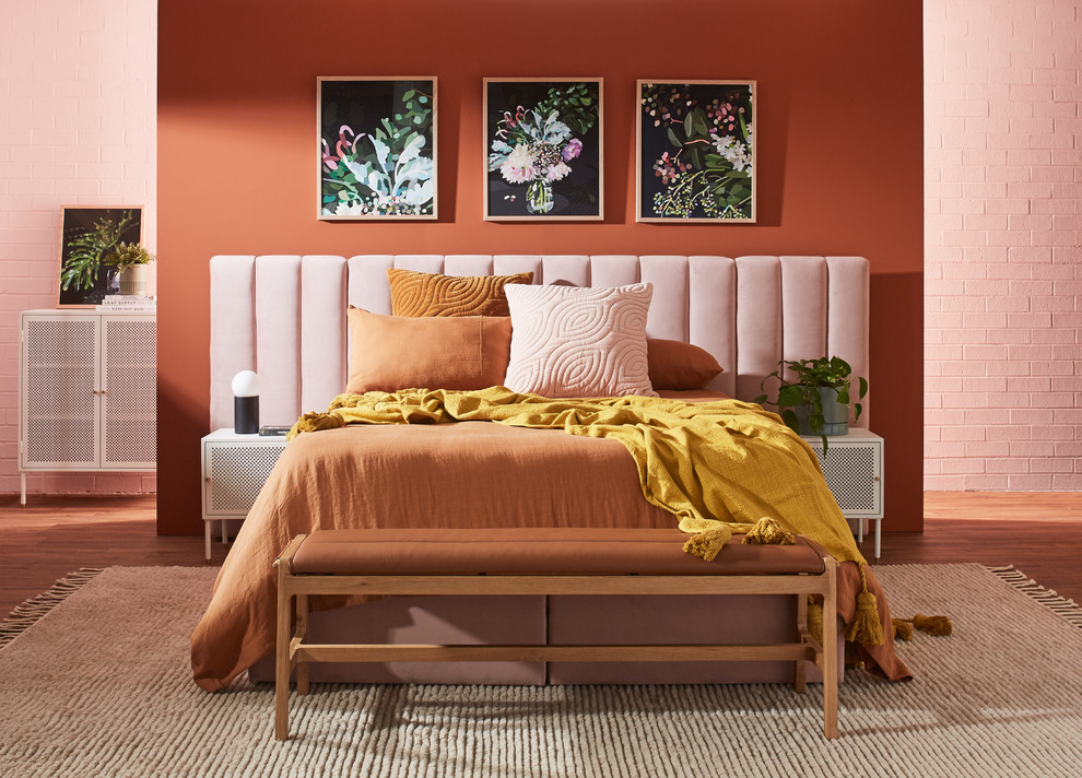 Exemple d'une chambre parentale tendance de taille moyenne avec un mur orange, un sol en vinyl et un sol marron.