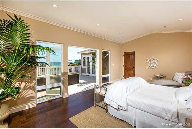 Ejemplo de dormitorio principal marinero grande con paredes blancas y suelo de madera en tonos medios