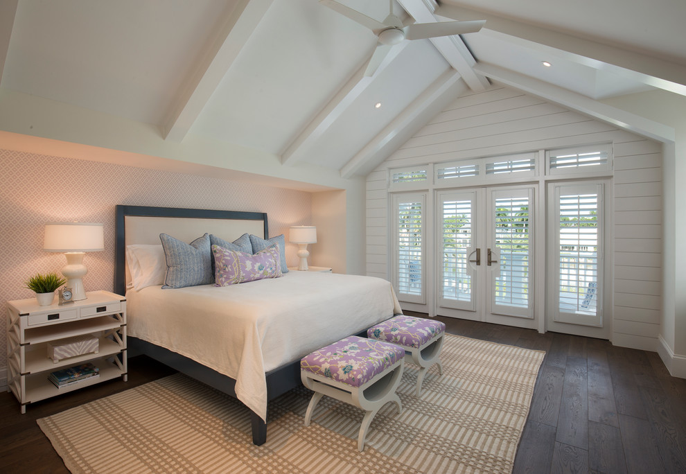 Beach style bedroom in Miami with white walls, dark hardwood flooring and a feature wall.