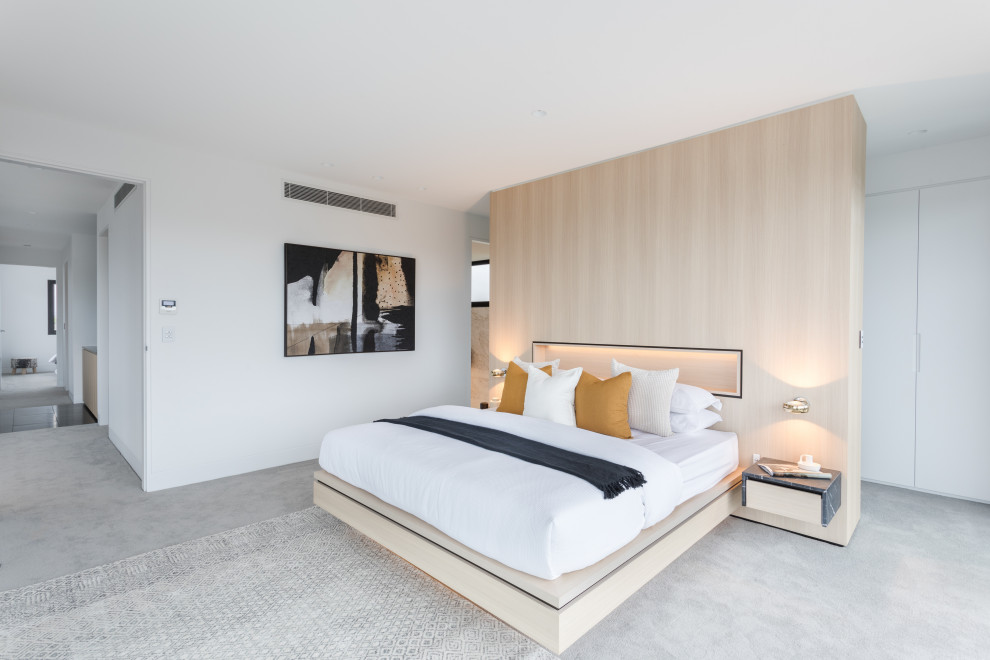 Immagine di una camera da letto contemporanea con pareti bianche e pavimento grigio