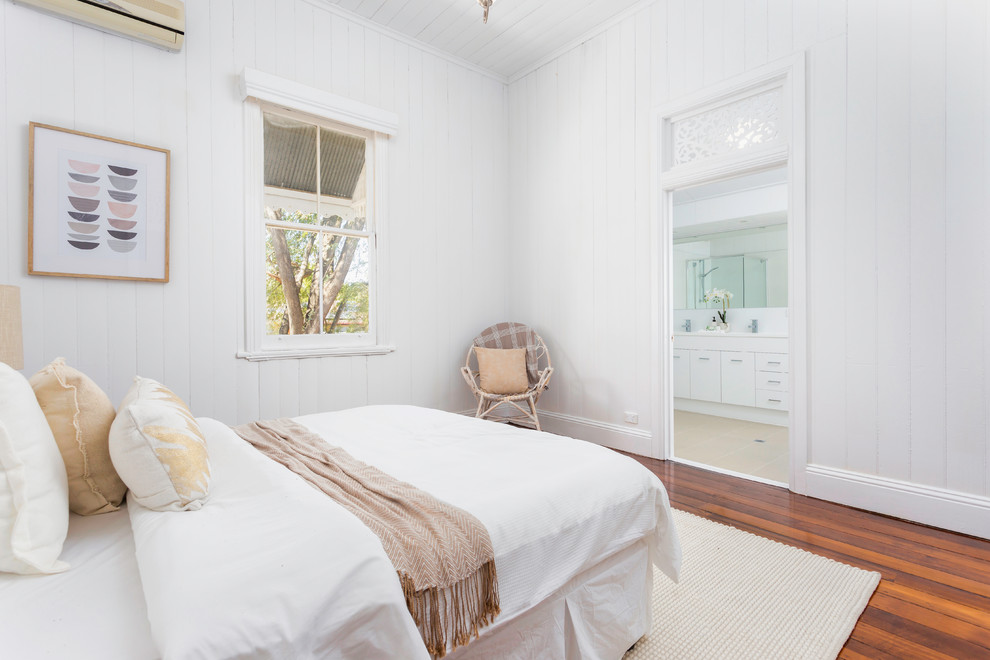 Nordisches Hauptschlafzimmer mit weißer Wandfarbe, braunem Holzboden und braunem Boden in Brisbane
