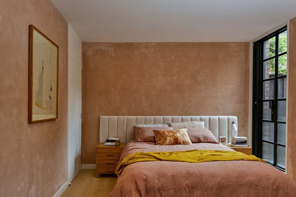 Idéer för funkis sovrum, med rosa väggar, mellanmörkt trägolv och brunt golv