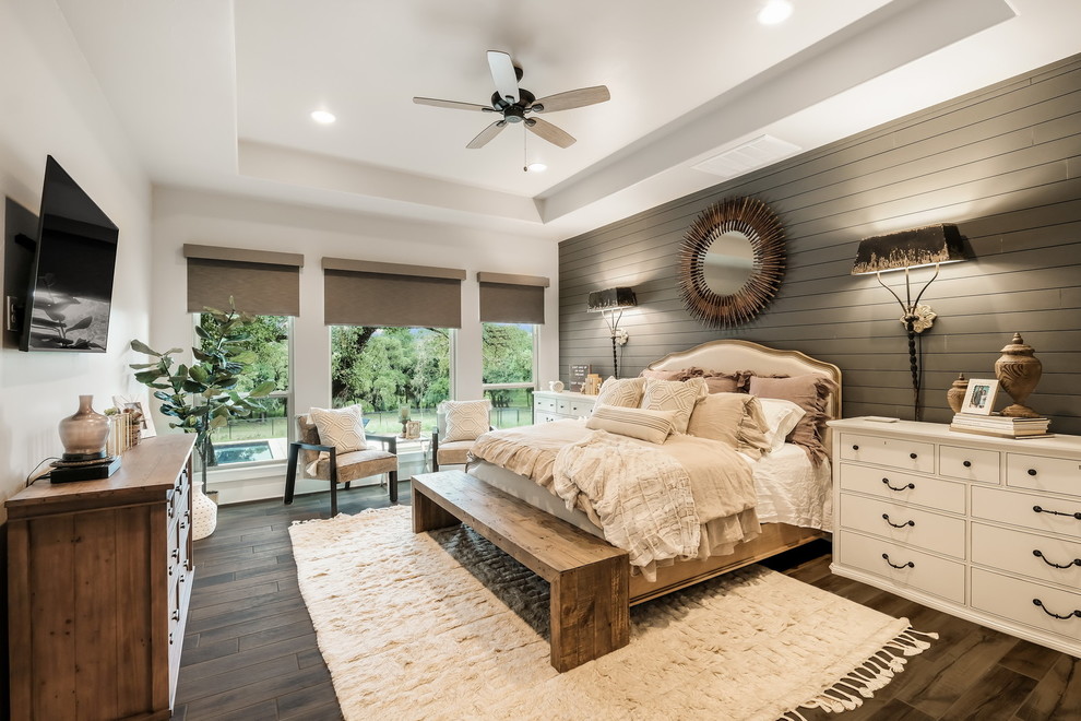 Transitional medium tone wood floor and brown floor bedroom photo in Austin with white walls and no fireplace