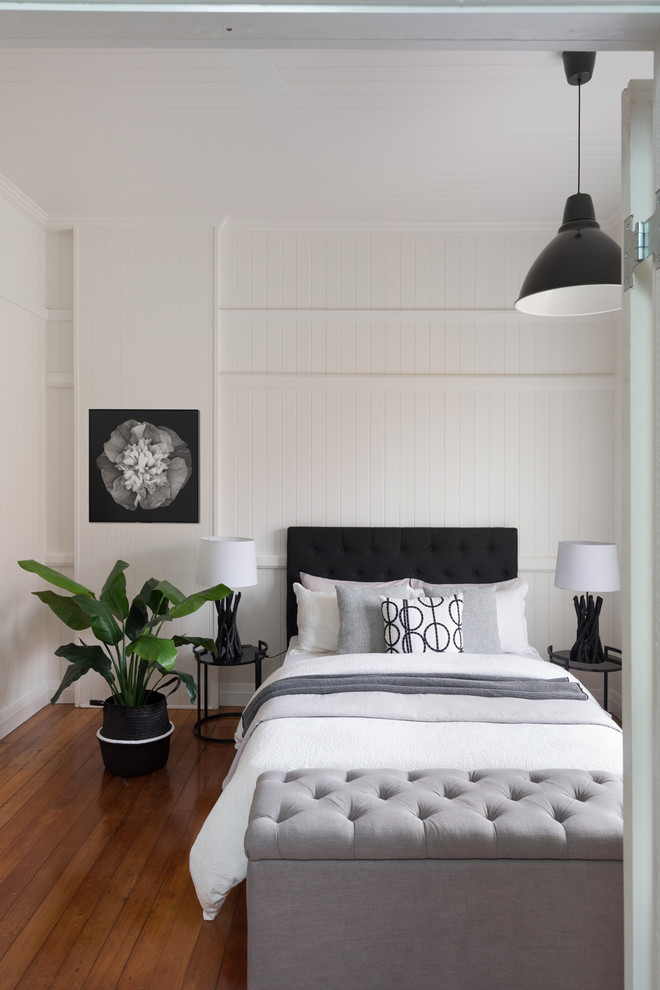 Foto på ett maritimt sovrum, med vita väggar, mellanmörkt trägolv och brunt golv