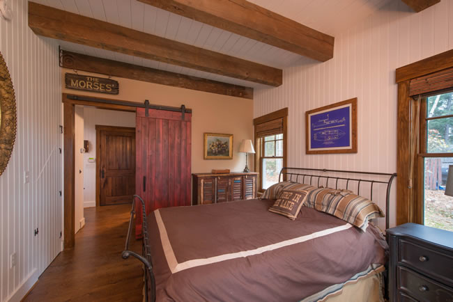 Mittelgroßes Landhaus Hauptschlafzimmer ohne Kamin mit weißer Wandfarbe, dunklem Holzboden und braunem Boden in Sonstige