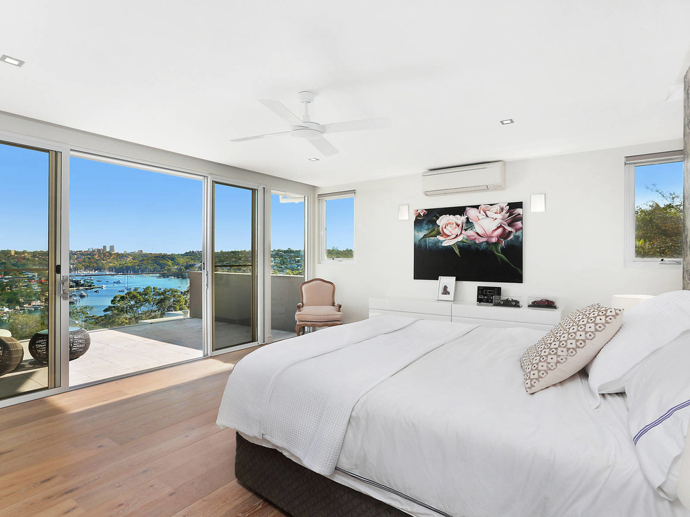 Großes Modernes Hauptschlafzimmer mit weißer Wandfarbe und hellem Holzboden in Sydney