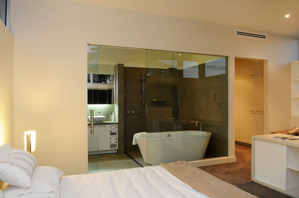 シドニーにある広いコンテンポラリースタイルのおしゃれな主寝室 (白い壁、カーペット敷き、暖炉なし、茶色い床) のインテリア