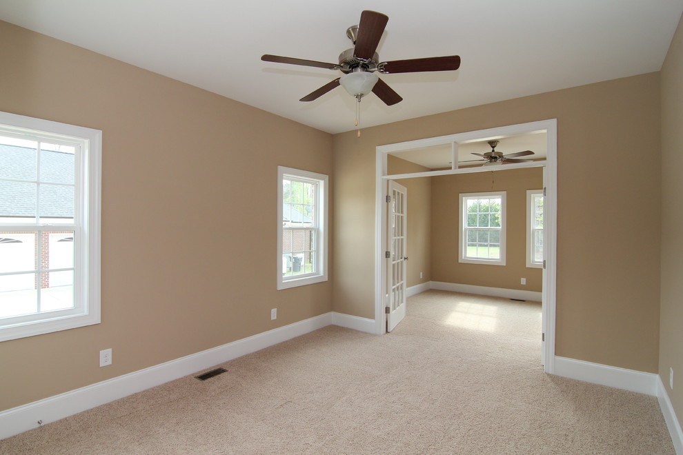 Example of a large classic guest carpeted bedroom design in Raleigh with beige walls