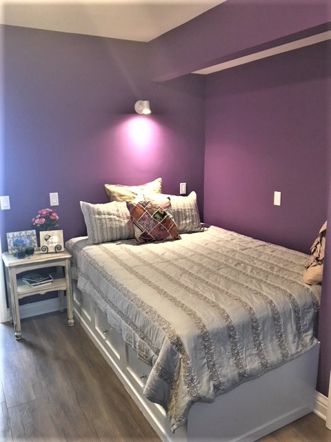 ロサンゼルスにある中くらいなエクレクティックスタイルのおしゃれな客用寝室 (ラミネートの床、ベージュの床、紫の壁) のインテリア