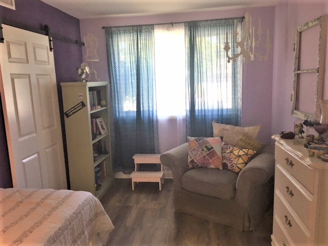 Modelo de habitación de invitados bohemia de tamaño medio con paredes púrpuras, suelo laminado y suelo beige