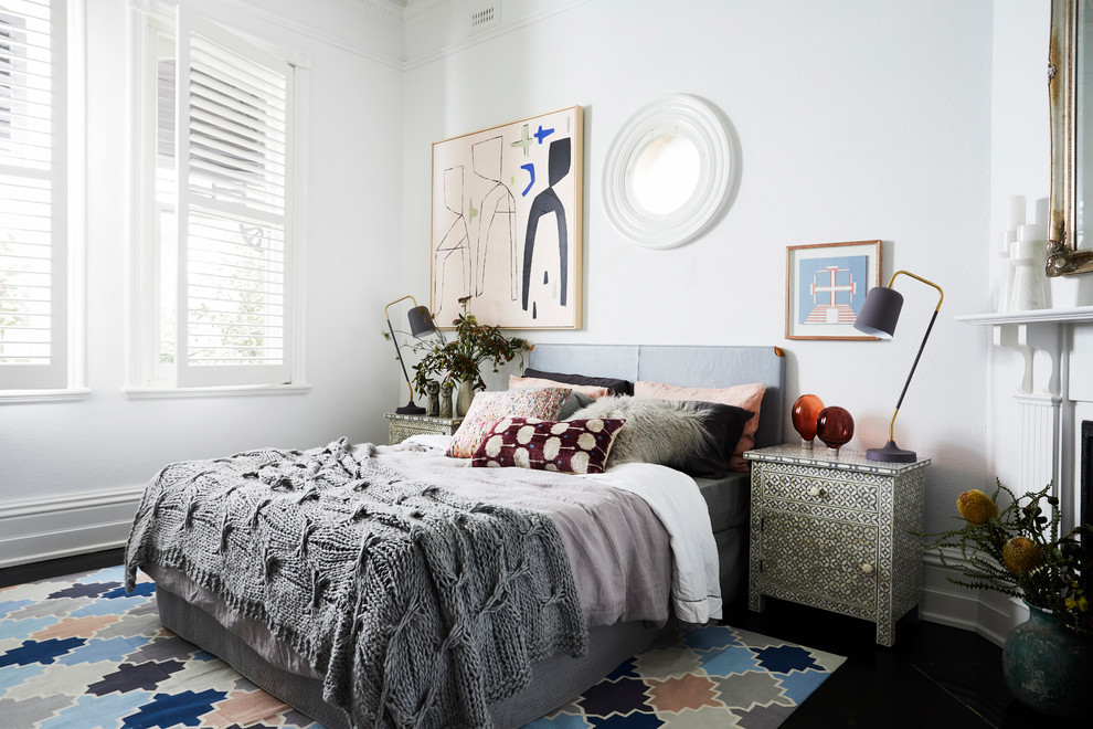 Modernes Hauptschlafzimmer mit weißer Wandfarbe, Kamin und schwarzem Boden in Melbourne