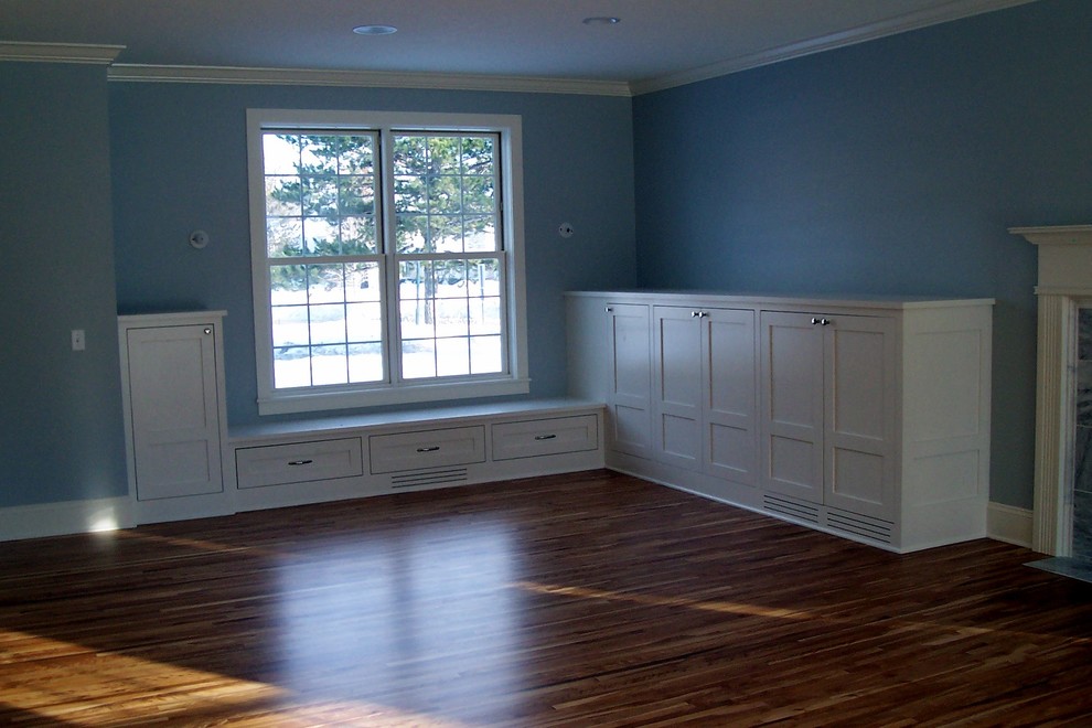 Ejemplo de habitación de invitados tradicional de tamaño medio con paredes azules, suelo de madera en tonos medios, todas las chimeneas y marco de chimenea de baldosas y/o azulejos