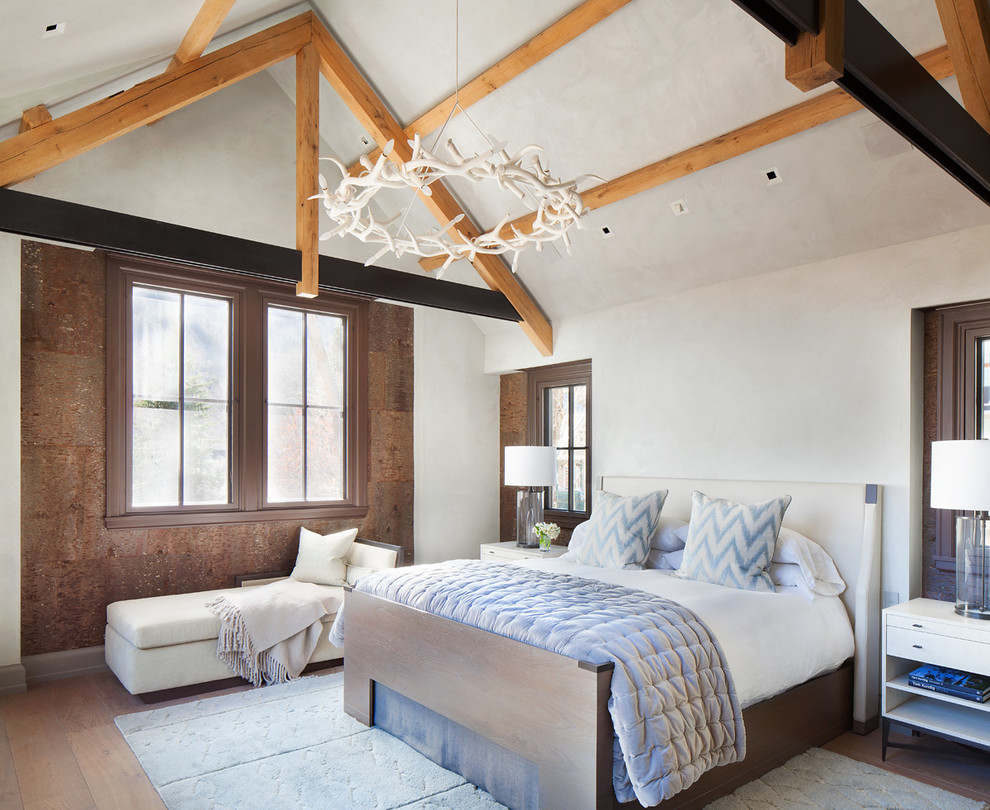 Rustic grey and brown bedroom in Denver with white walls, medium hardwood flooring and a feature wall.