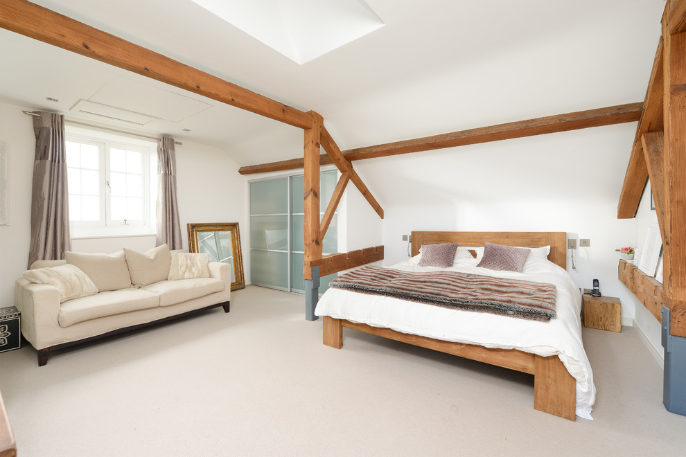 Photo of a farmhouse bedroom in Kent with white walls, carpet and grey floors.