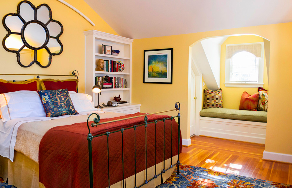 Foto de habitación de invitados de estilo americano de tamaño medio sin chimenea con paredes amarillas y suelo de madera en tonos medios
