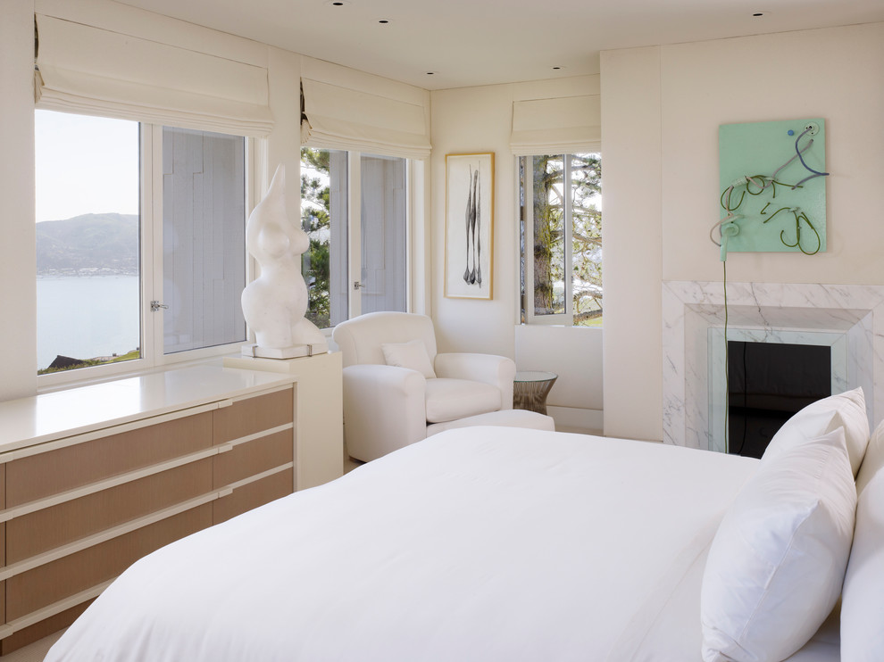 Inspiration för moderna sovrum, med beige väggar och en standard öppen spis