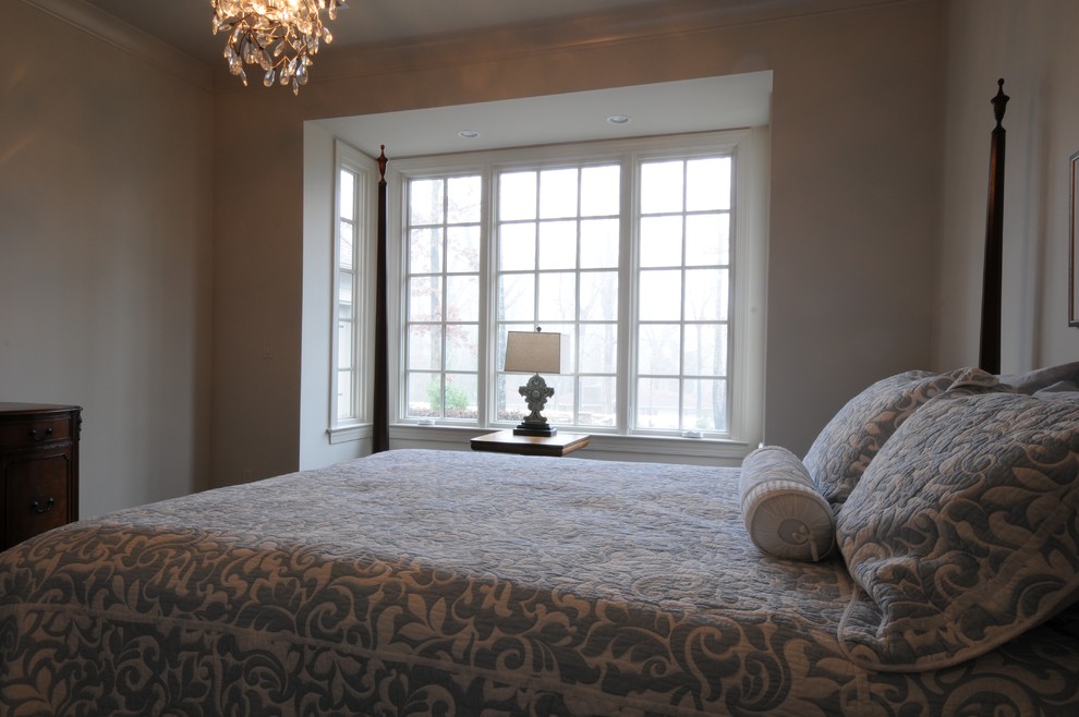Imagen de dormitorio principal tradicional grande sin chimenea con paredes beige, suelo de madera oscura y suelo marrón