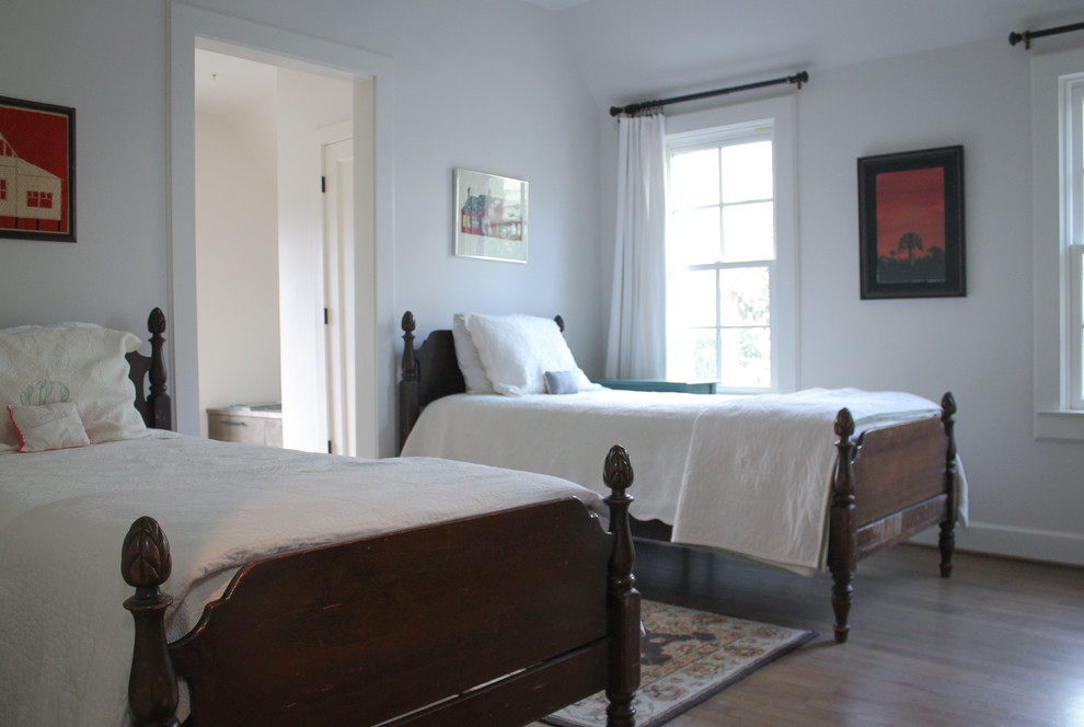 Aménagement d'une chambre d'amis craftsman de taille moyenne avec un mur blanc, un sol en bois brun et un sol marron.