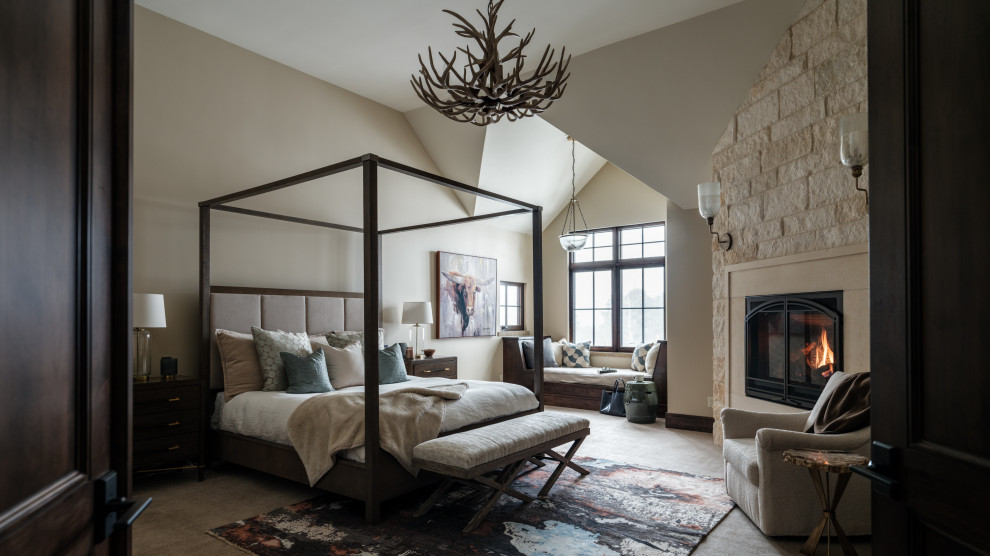 Large rustic master bedroom in Denver with beige walls, carpet, a standard fireplace, a stone fireplace surround and beige floors.