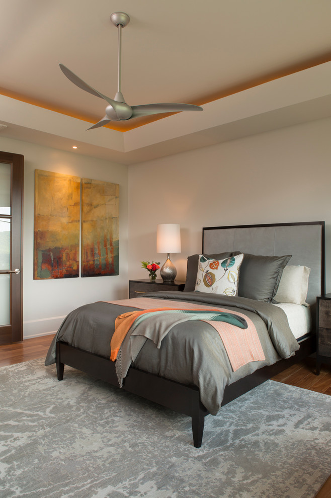 Foto de dormitorio principal actual grande sin chimenea con paredes beige y suelo de madera en tonos medios