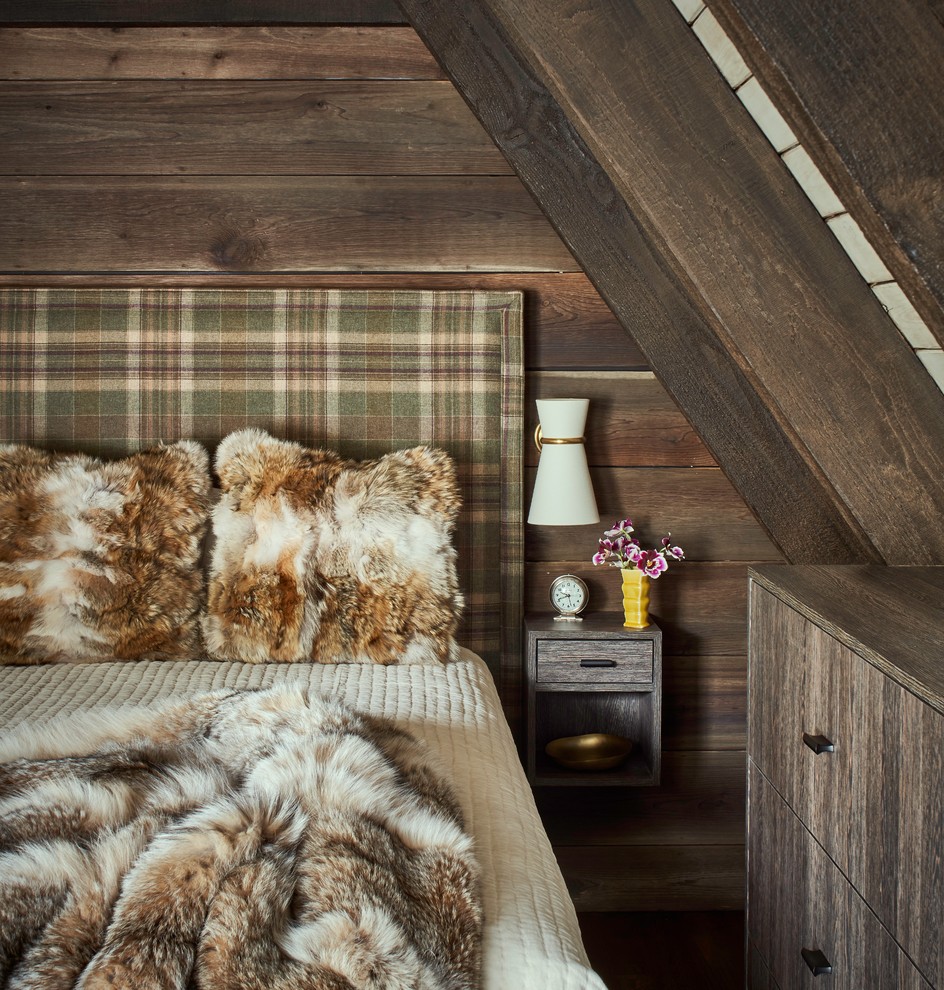 Uriges Schlafzimmer mit brauner Wandfarbe, dunklem Holzboden und braunem Boden in Sonstige