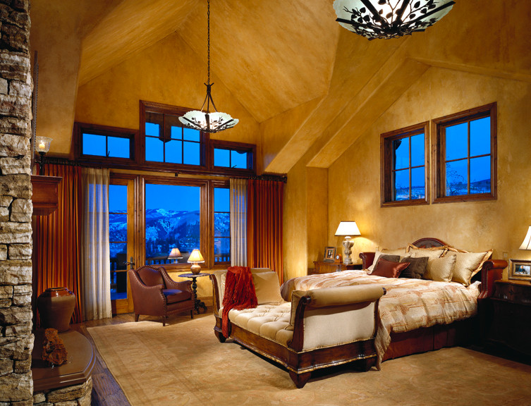 Foto de dormitorio principal clásico grande con suelo de madera oscura, marco de chimenea de piedra y todas las chimeneas