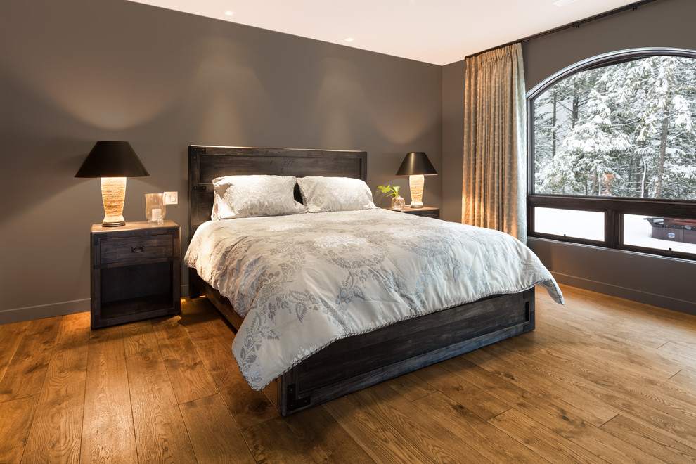 Design ideas for a large rustic master bedroom in Vancouver with grey walls and medium hardwood flooring.