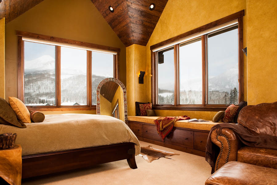 Inspiration for a large rustic master carpeted bedroom remodel in Albuquerque with yellow walls