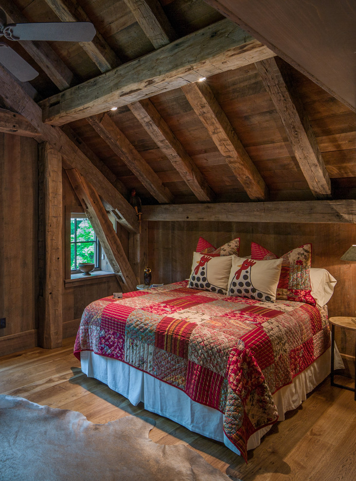 Immagine di una camera da letto stile rurale con pavimento in legno massello medio