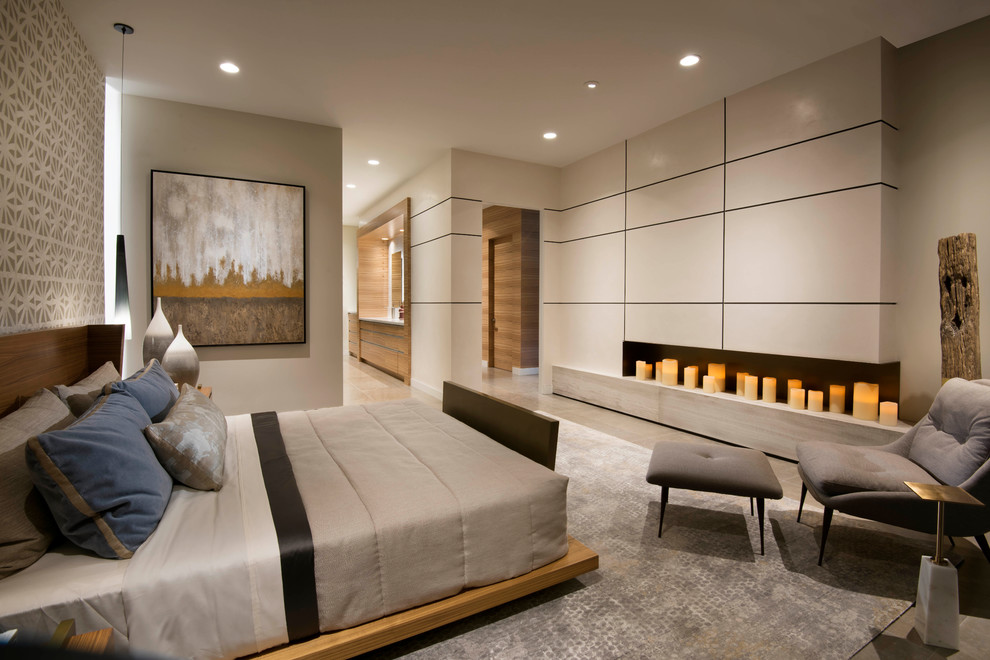 Imagen de dormitorio principal contemporáneo grande con paredes beige, suelo de piedra caliza, chimenea lineal y suelo beige