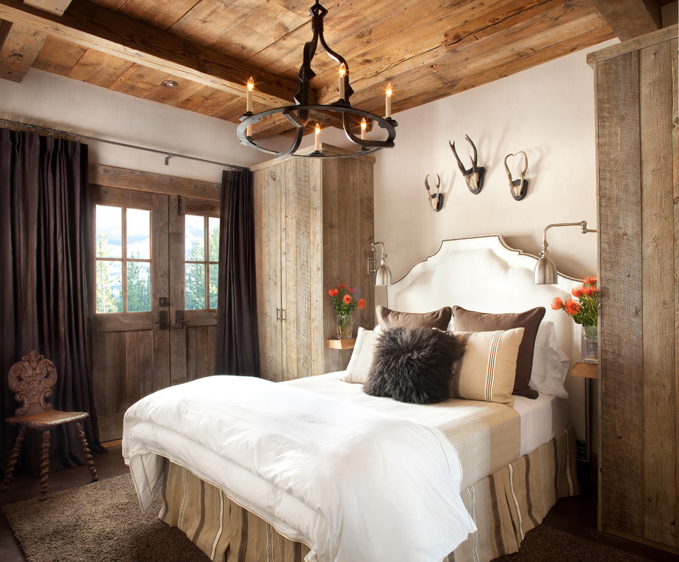 Mittelgroßes Uriges Hauptschlafzimmer mit weißer Wandfarbe, dunklem Holzboden und braunem Boden in Sonstige
