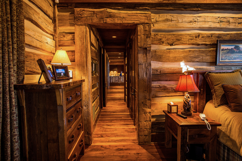 Foto de habitación de invitados rural de tamaño medio con paredes marrones y suelo de madera oscura