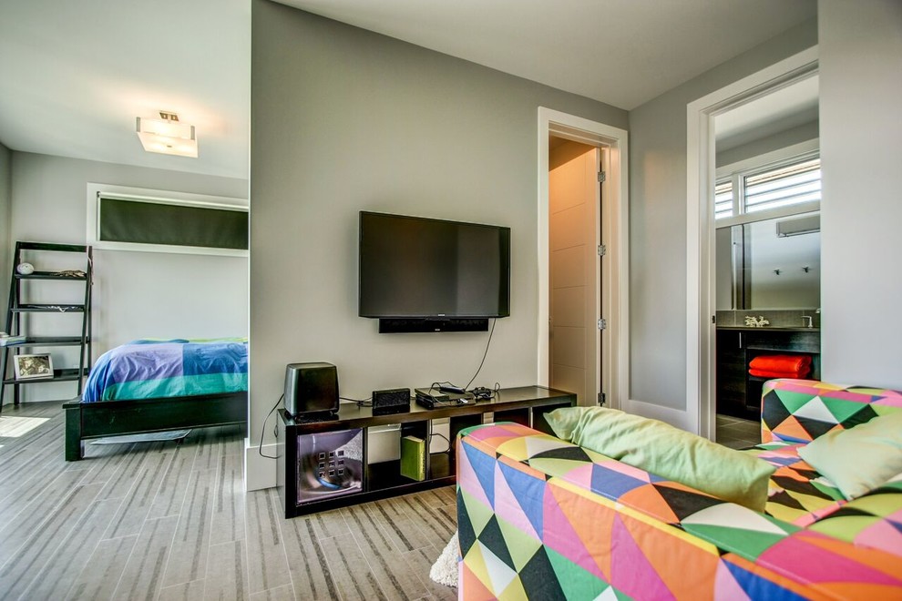 Foto de habitación de invitados contemporánea grande con paredes grises y suelo de madera clara