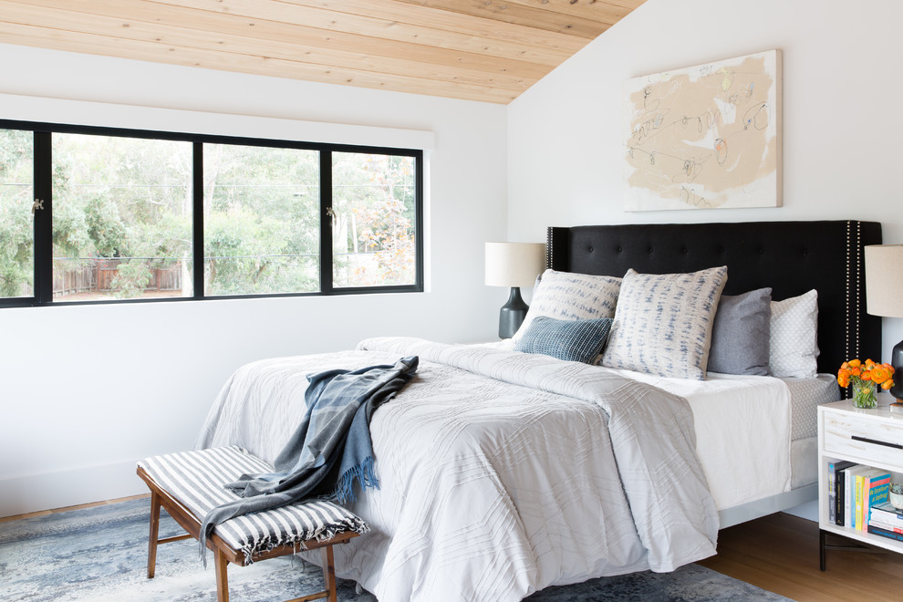 Inspiration för lantliga sovrum, med vita väggar och mellanmörkt trägolv